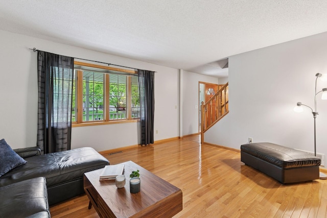 1502 Rocky Ln, Eagan, MN 55122 - living area with light wood finished floors, baseboards, stairway, and a textured ceiling