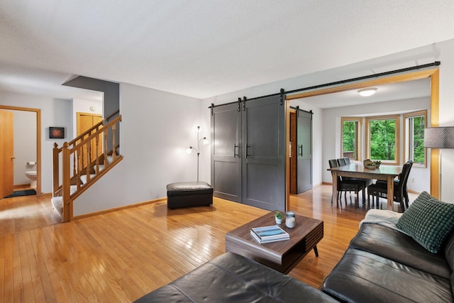1502 Rocky Ln, Eagan, MN 55122 - living area with a barn door, light wood finished floors, stairs, and baseboards