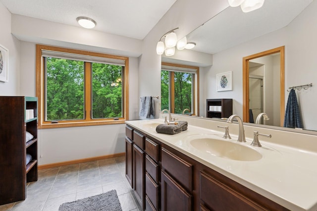 1502 Rocky Ln, Eagan, MN 55122 - bathroom featuring double vanity, baseboards, tile patterned floors, and an enclosed shower
