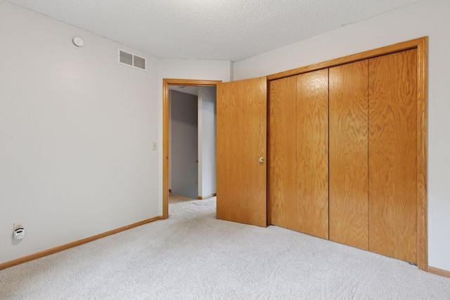 1502 Rocky Ln, Eagan, MN 55122 - unfurnished bedroom featuring light carpet, a closet, a textured ceiling, and baseboards