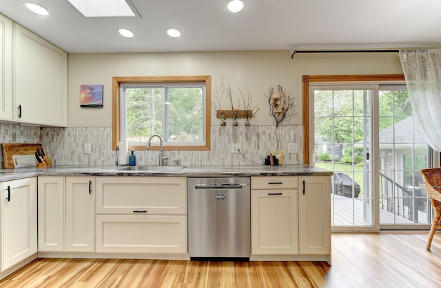 3021 Crescent Ln NW, Rochester, MN 55901 - kitchen with dishwasher, a sink, light wood-style floors, a skylight, and backsplash