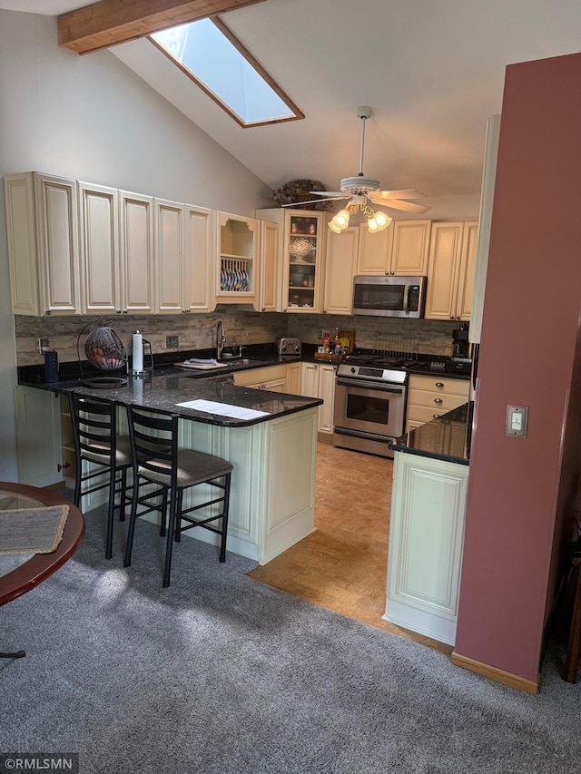 6800 Buckingham Ct, Woodbury, MN 55125 - kitchen with stainless steel appliances, a peninsula, a sink, dark countertops, and tasteful backsplash