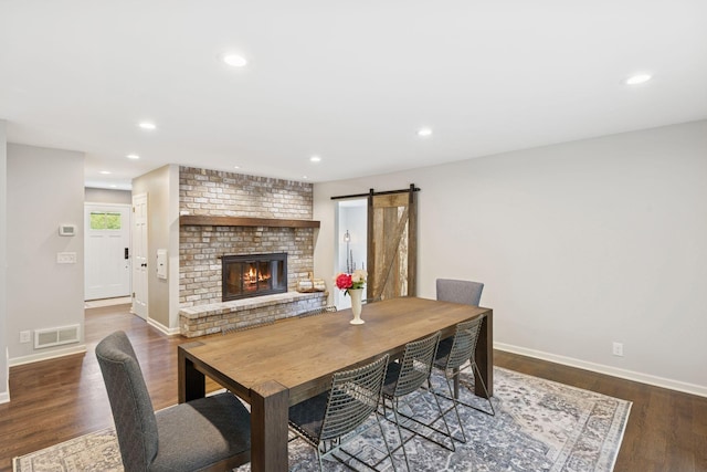 200 Marie Ave W, West Saint Paul, MN 55118 - dining space featuring wood finished floors, a brick fireplace, recessed lighting, and a barn door