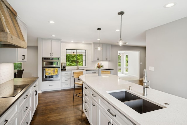 200 Marie Ave W, West Saint Paul, MN 55118 - kitchen featuring black electric cooktop, custom range hood, stainless steel double oven, tasteful backsplash, and healthy amount of natural light
