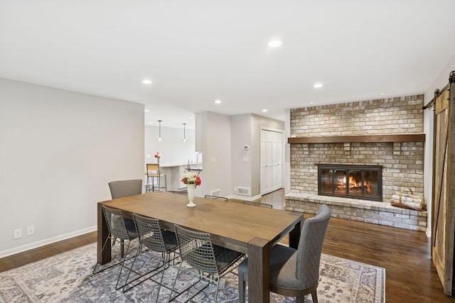 200 Marie Ave W, West Saint Paul, MN 55118 - dining space with a barn door, wood finished floors, a fireplace, and recessed lighting
