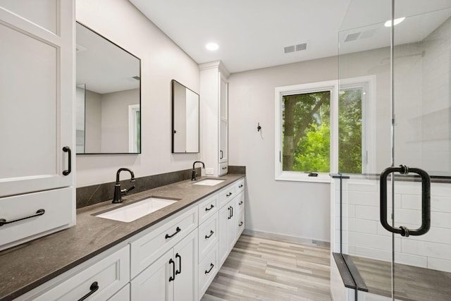 200 Marie Ave W, West Saint Paul, MN 55118 - full bathroom with double vanity, wood finished floors, a stall shower, and recessed lighting