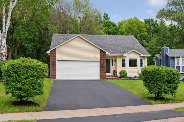 17698 Shore Ln W, Eden Prairie, MN 55346 - view of front of property with an attached garage, driveway, a front lawn, brick siding, and roof with shingles