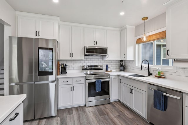 17698 Shore Ln W, Eden Prairie, MN 55346 - kitchen with stainless steel appliances, a sink, tasteful backsplash, dark wood-style flooring, and white cabinets