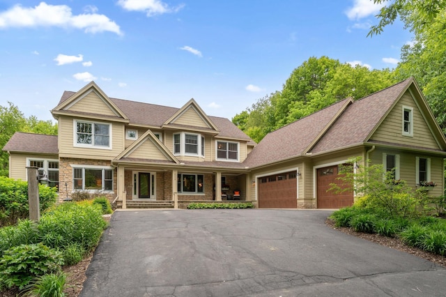 6539 Orchard Ridge Trl, Woodbury, MN 55129 - craftsman-style home featuring an attached garage, asphalt driveway, a porch, roof with shingles, and stone siding