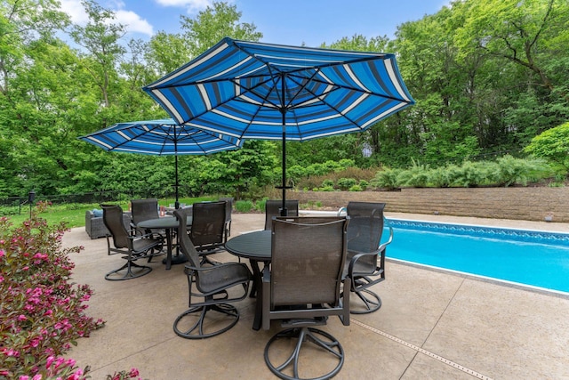 6539 Orchard Ridge Trl, Woodbury, MN 55129 - view of patio with an outdoor pool, outdoor dining space, and view of wooded area