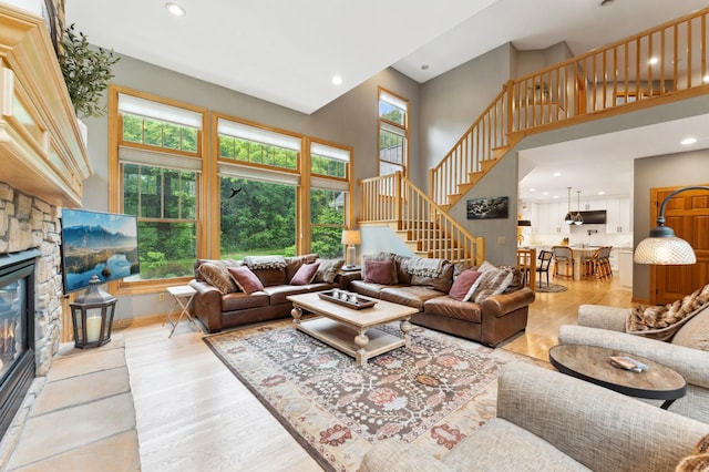 6539 Orchard Ridge Trl, Woodbury, MN 55129 - living room featuring a towering ceiling, stairs, recessed lighting, wood finished floors, and a stone fireplace