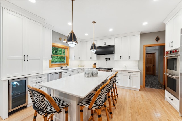 6539 Orchard Ridge Trl, Woodbury, MN 55129 - kitchen featuring wine cooler, stainless steel appliances, a sink, under cabinet range hood, and a breakfast bar