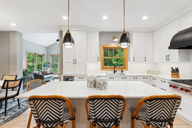 6539 Orchard Ridge Trl, Woodbury, MN 55129 - kitchen with a sink, light wood-type flooring, a kitchen bar, recessed lighting, and lofted ceiling