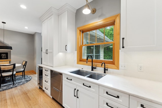 6539 Orchard Ridge Trl, Woodbury, MN 55129 - kitchen with stainless steel dishwasher, a sink, light wood-style floors, tasteful backsplash, and recessed lighting