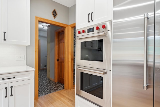 6539 Orchard Ridge Trl, Woodbury, MN 55129 - kitchen with appliances with stainless steel finishes, white cabinets, light wood-style floors, and light countertops
