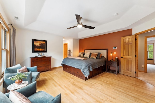 6539 Orchard Ridge Trl, Woodbury, MN 55129 - bedroom featuring a raised ceiling, light wood finished floors, baseboards, and ceiling fan