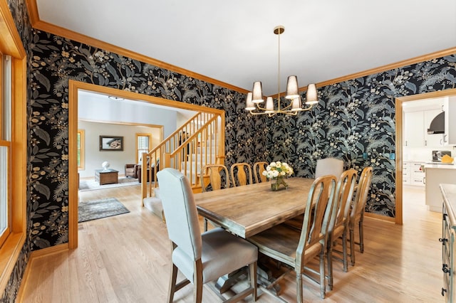 6539 Orchard Ridge Trl, Woodbury, MN 55129 - dining area with wallpapered walls, a chandelier, light wood-type flooring, stairs, and crown molding