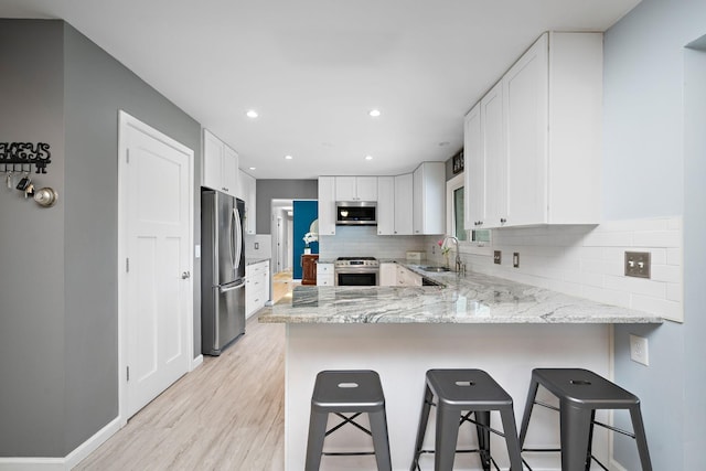 1305 Unity Ave N, Golden Valley, MN 55422 - kitchen featuring stainless steel appliances, a sink, light wood-type flooring, a peninsula, and tasteful backsplash