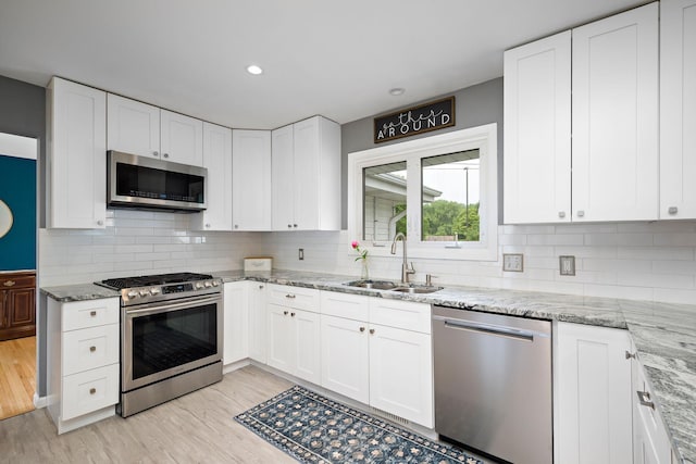 1305 Unity Ave N, Golden Valley, MN 55422 - kitchen featuring stainless steel appliances, a sink, white cabinetry, light stone counters, and recessed lighting