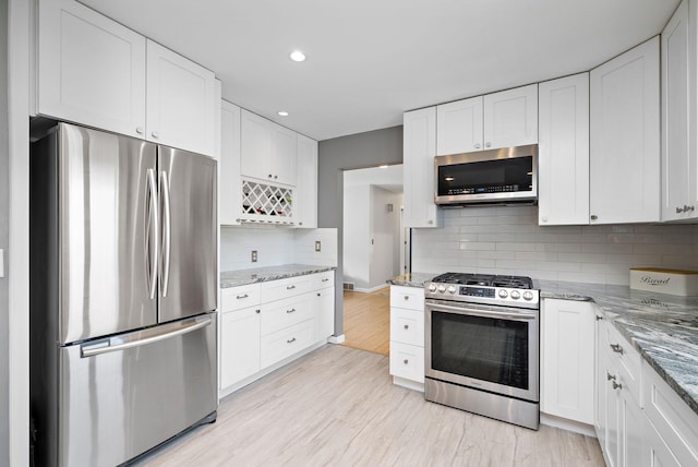1305 Unity Ave N, Golden Valley, MN 55422 - kitchen featuring appliances with stainless steel finishes, white cabinets, light stone counters, light wood-style floors, and recessed lighting