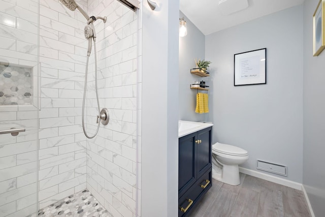 1305 Unity Ave N, Golden Valley, MN 55422 - bathroom featuring vanity, a tile shower, toilet, and baseboards
