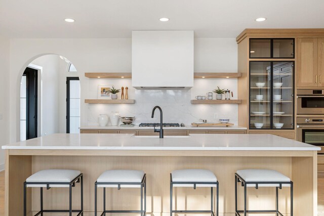 kitchen featuring open shelves, tasteful backsplash, light countertops, recessed lighting, and arched walkways