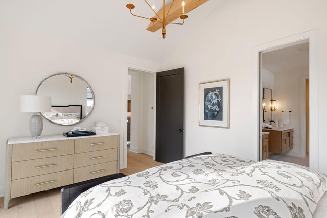 bedroom featuring a chandelier, light wood-style flooring, and high vaulted ceiling