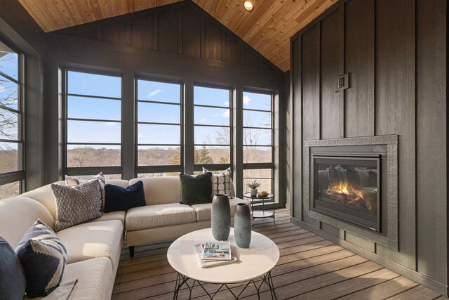 living area with wooden ceiling, vaulted ceiling, a glass covered fireplace, light wood-type flooring, and recessed lighting