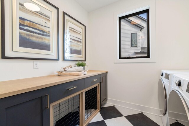 laundry area with washing machine and dryer, baseboards, cabinet space, and plenty of natural light