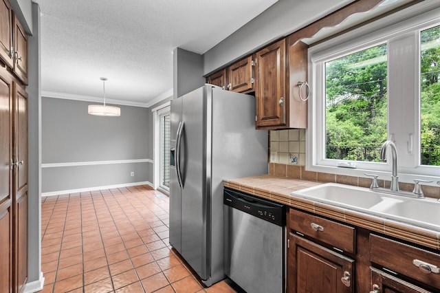 6331 Saint Croix Trl N, Stillwater, MN 55082 - kitchen with stainless steel appliances, a sink, light tile patterned floors, tile countertops, and decorative light fixtures