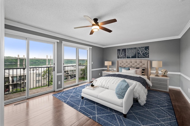 6331 Saint Croix Trl N, Stillwater, MN 55082 - bedroom featuring access to exterior, wood finished floors, a water view, a textured ceiling, and crown molding