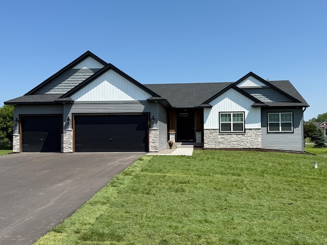 3309 171st Ave NE, Ham Lake, MN 55304 - view of front of home featuring stone siding, an attached garage, a front yard, and driveway