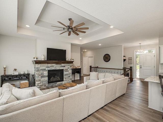 3309 171st Ave NE, Ham Lake, MN 55304 - living area featuring ceiling fan, a tray ceiling, light wood-type flooring, recessed lighting, and a fireplace