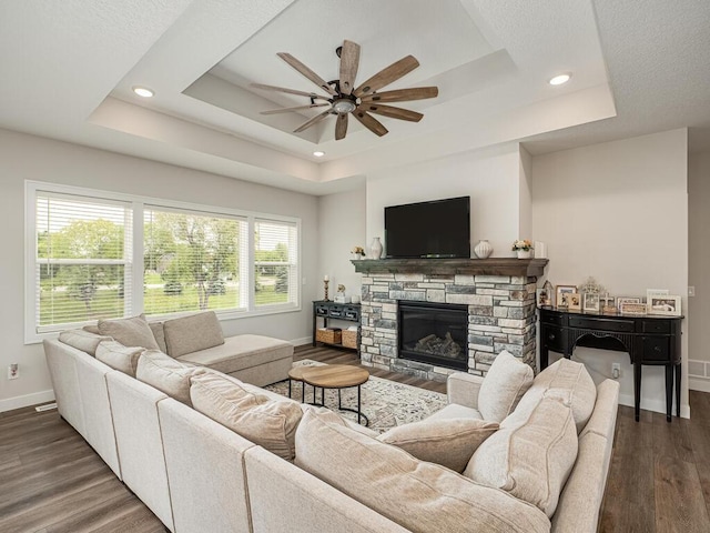 3309 171st Ave NE, Ham Lake, MN 55304 - living area with a raised ceiling, a ceiling fan, wood finished floors, recessed lighting, and a stone fireplace