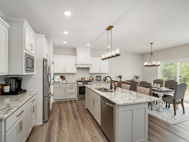 3309 171st Ave NE, Ham Lake, MN 55304 - kitchen featuring appliances with stainless steel finishes, wood finished floors, a chandelier, tasteful backsplash, and recessed lighting