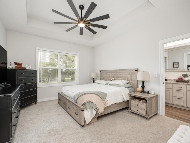3309 171st Ave NE, Ham Lake, MN 55304 - bedroom featuring a raised ceiling, light carpet, ensuite bathroom, and a ceiling fan