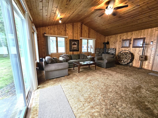 27042 Bluebill Point Rd, Garrison, MN 56450 - carpeted living area featuring vaulted ceiling, a wood stove, ceiling fan, wood walls, and wooden ceiling