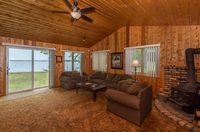 27042 Bluebill Point Rd, Garrison, MN 56450 - living room featuring wooden walls, a wood stove, lofted ceiling, wood ceiling, and carpet flooring