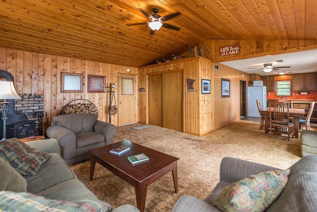 27042 Bluebill Point Rd, Garrison, MN 56450 - carpeted living area with ceiling fan, vaulted ceiling, wood walls, a wood stove, and wooden ceiling