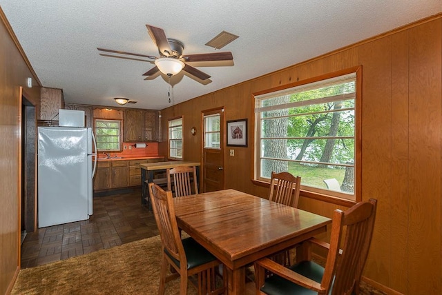 27042 Bluebill Point Rd, Garrison, MN 56450 - dining space with a textured ceiling, ceiling fan, and wooden walls