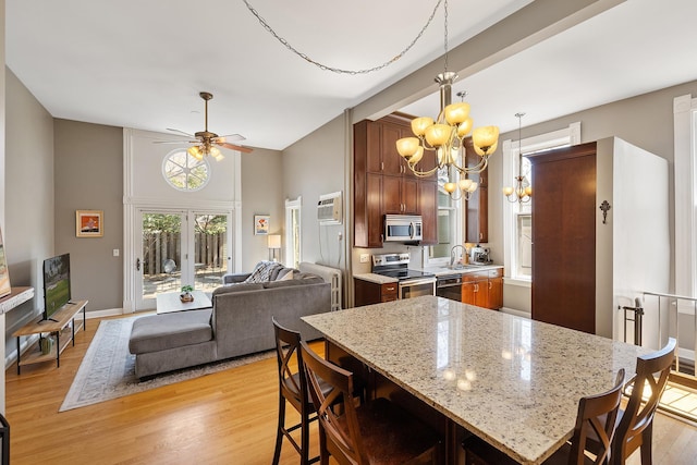 112 Western Ave N Unit 4, Saint Paul, MN 55102 - kitchen featuring stainless steel appliances, a chandelier, a kitchen breakfast bar, and light wood-style floors