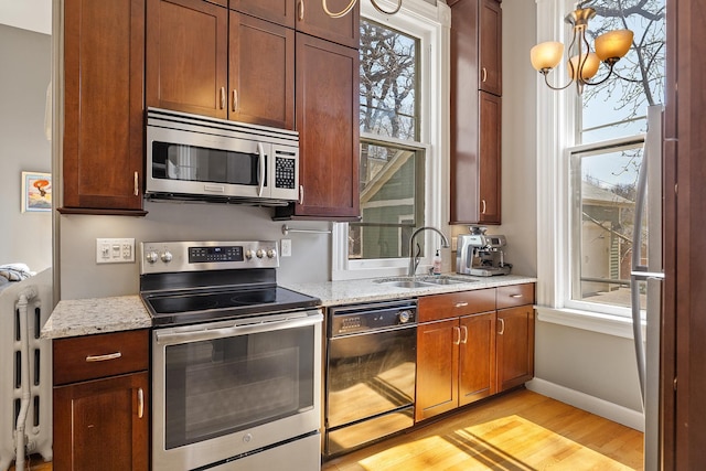 112 Western Ave N Unit 4, Saint Paul, MN 55102 - kitchen with appliances with stainless steel finishes, a sink, light wood-type flooring, baseboards, and radiator