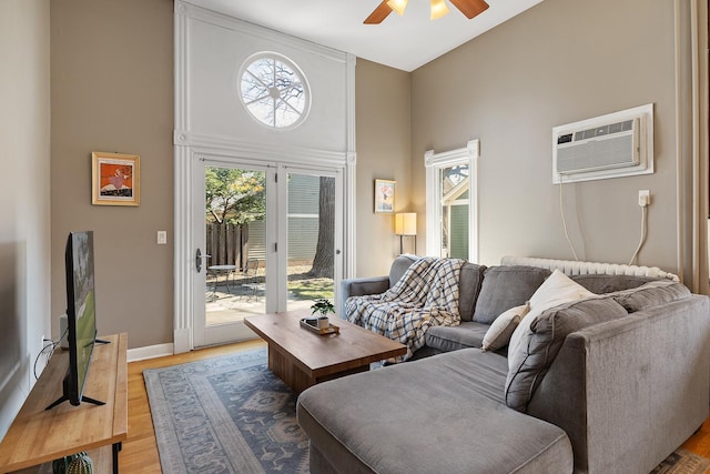 112 Western Ave N Unit 4, Saint Paul, MN 55102 - living room with a ceiling fan, a towering ceiling, a wall mounted air conditioner, wood finished floors, and baseboards