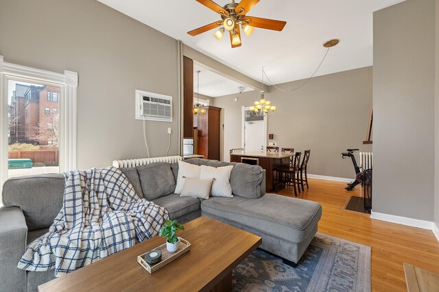 112 Western Ave N Unit 4, Saint Paul, MN 55102 - living area with a chandelier, light wood-style floors, a wall mounted air conditioner, a ceiling fan, and baseboards