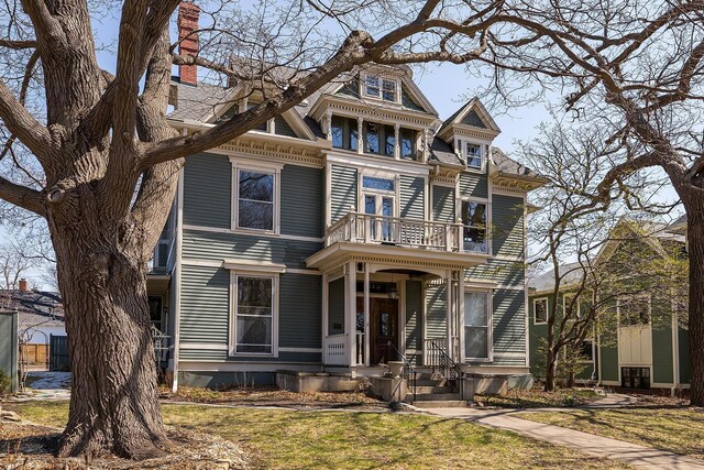 112 Western Ave N Unit 4, Saint Paul, MN 55102 - victorian house with a balcony, a chimney, covered porch, and a front yard