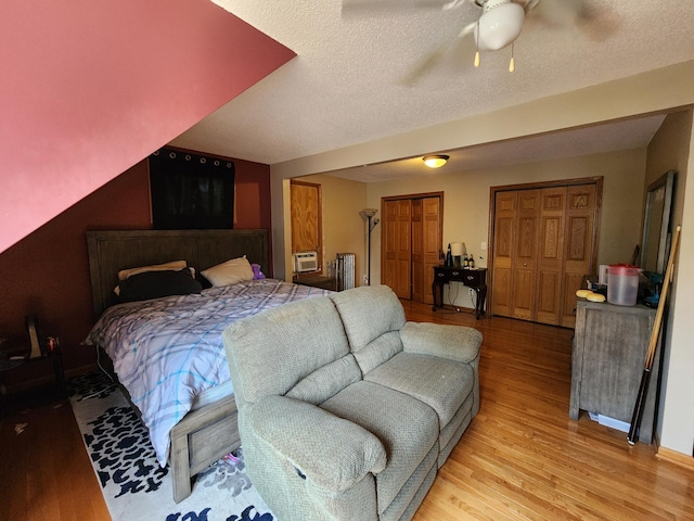 315 3rd St SW, Stewartville, MN 55976 - bedroom with light wood-type flooring, multiple closets, radiator, a ceiling fan, and a textured ceiling