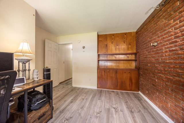 836 Milligan Ave, Wabasha, MN 55981 - office area with brick wall, light wood-style floors, and baseboards