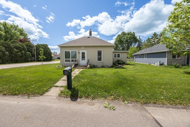 836 Milligan Ave, Wabasha, MN 55981 - bungalow-style home with a front yard, a chimney, cooling unit, and entry steps