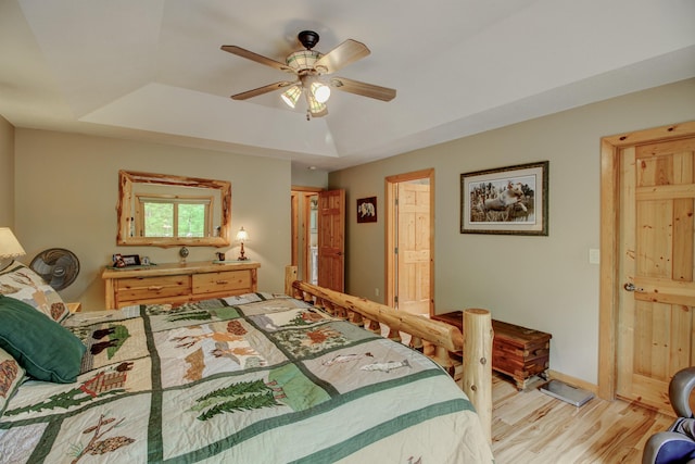 8824 Bittersweet Cir, Breezy Point, MN 56472 - bedroom with light wood-type flooring, a tray ceiling, baseboards, and a ceiling fan