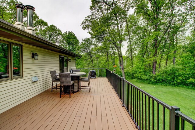 8824 Bittersweet Cir, Breezy Point, MN 56472 - wooden deck with outdoor dining area, a yard, and view of wooded area